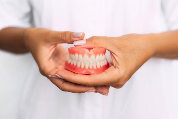 person holding dentures | dentures white hills vic
