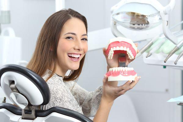 woman smiling in dental chair | tooth extractions white hills